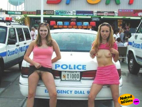 Two chicks flashing their tits and pussy right next to a cop car
