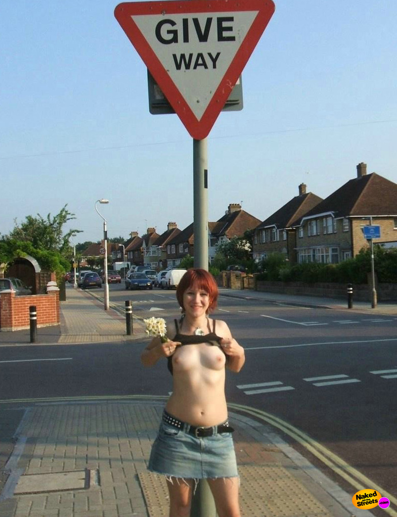 Redhead girlie shows off her boobies in the street