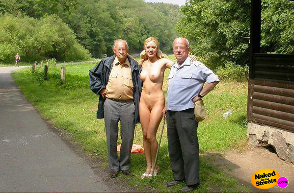 Blonde chick poses nude in the park with some grandpas