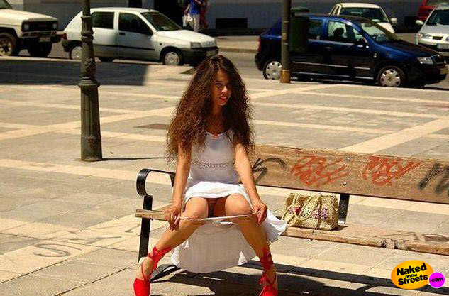 Exotic looking amateur flashing her pussy on a bench in the middle of a city
