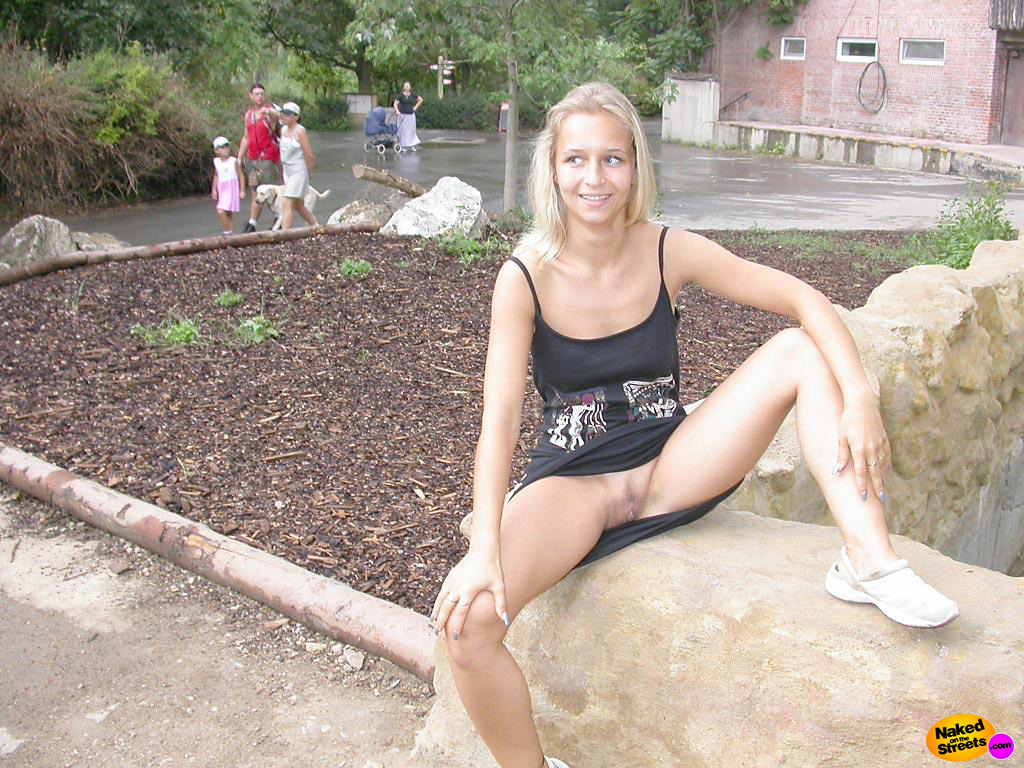 Young blonde girl exposing her pussy by sitting down with her legs spread