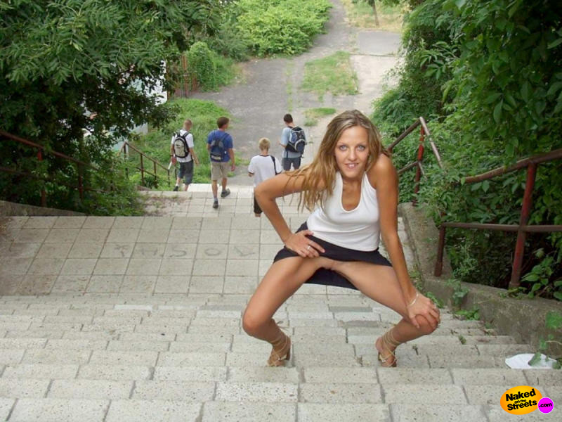 Thin teen slut shows off her snatch on some stairs