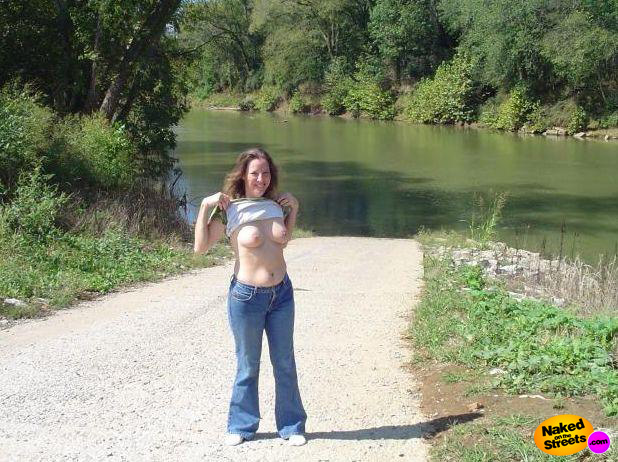 Amateur bitch flashign her big ass titties near a nice river bank