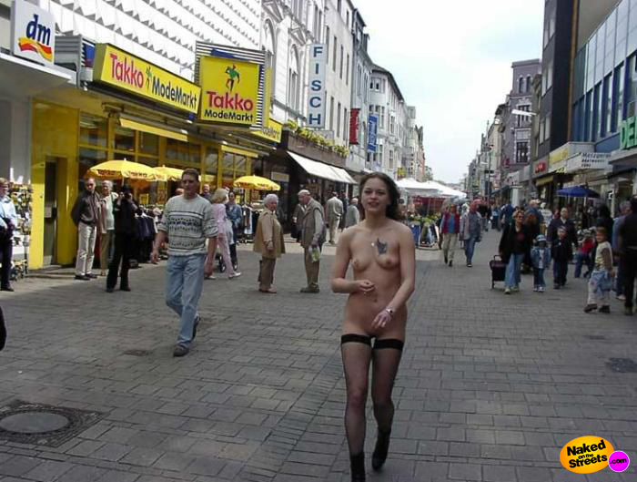 Teen chick with tatttoo on her tit walking through the city fully naked