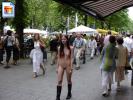 Young brunette teen walking through a busy shopping street fully nude