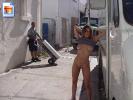 Very curvacious latina posing nude against a delivery truck in a side street