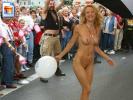 Laughing blonde girl walks naked in front of a crowd