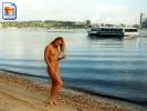 Blonde girl walks along the riverline with no clothes on