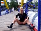 Crazy slut sits down on the pier and spreads her legs to flash her pussy