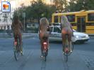 Three hot girls ride their bikes through the city fully nude