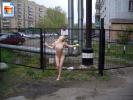 Kinky teen slut posing fully nude against a fence in a bad part of town