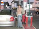 Chick shows off her tits while she gets some gas