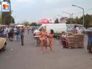 Two girls walking around fully naked at a market