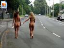 Two girls walking fully nude on the streets, showing their asses