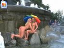 Two nude amateurs posing nude under an umbrellla