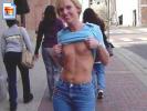 Laughing milf shows her titties in the street