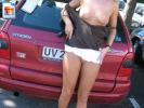 Naughty girl flashes her boobies near the car on her holiday