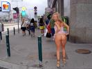 Laughing blonde girl shows her well formed booty in the street