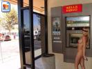 Hot American milf using an ATM-machine fully nude
