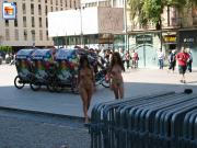 Two slender teenies walk around naked in the city centre