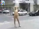 Crazy blonde girl stands around in the middle of the street naked