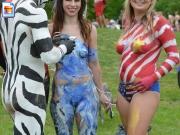 Cute girl goes to a festival wearing only bodypaint