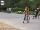 Hot young brunette chick riding a bike in the park, fully nude