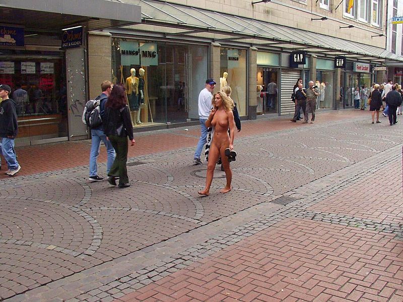 Crazy blonde slut walks through town wearing nothing at all