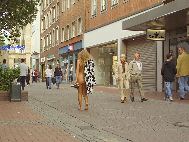 Crazy blonde slut walks through town wearing nothing at all