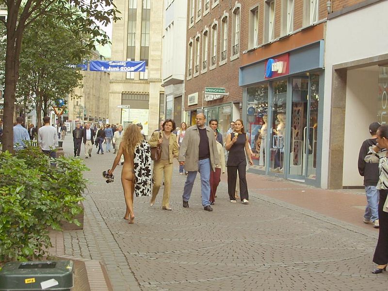 Crazy blonde slut walks through town wearing nothing at all