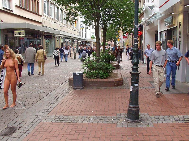 Crazy blonde slut walks through town wearing nothing at all