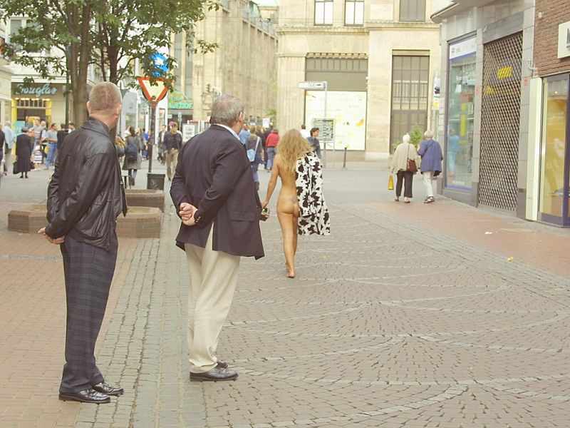 Crazy blonde slut walks through town wearing nothing at all