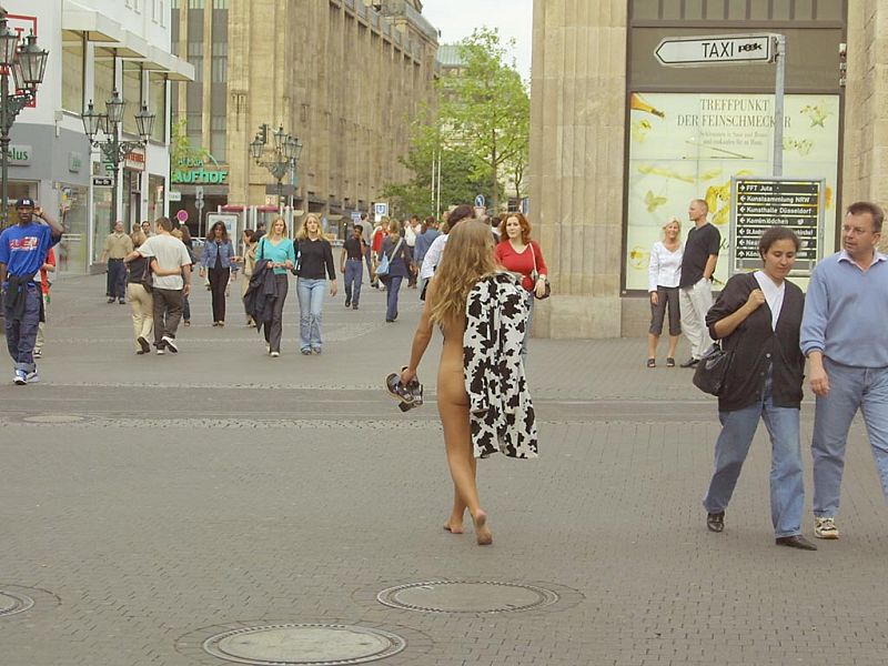 Crazy blonde slut walks through town wearing nothing at all