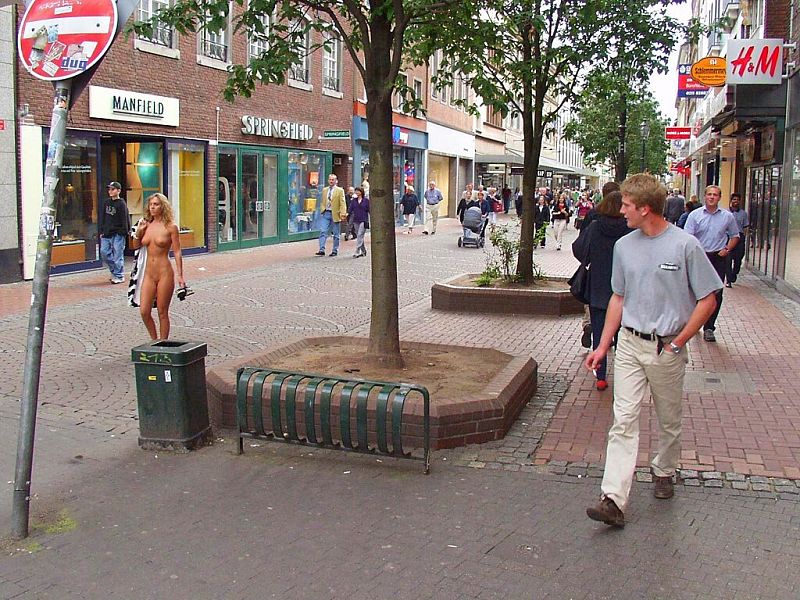 Crazy blonde slut walks through town wearing nothing at all