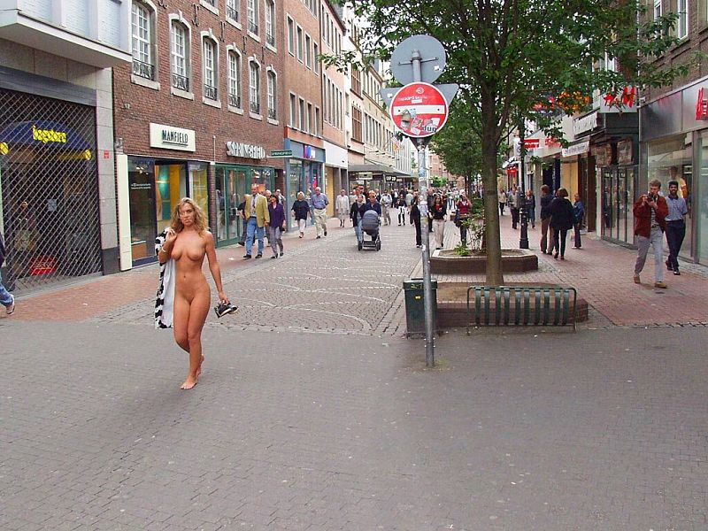 Crazy blonde slut walks through town wearing nothing at all