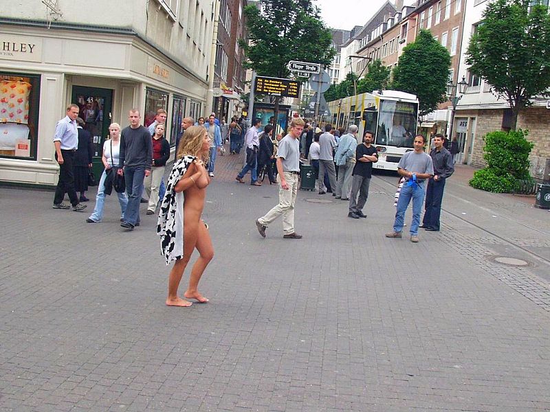 Crazy blonde slut walks through town wearing nothing at all