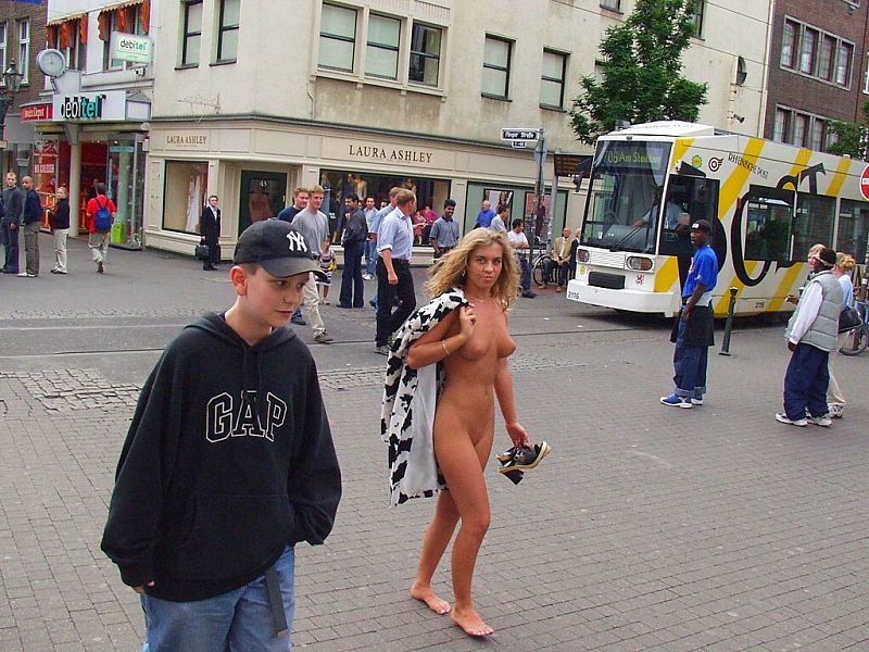 Crazy blonde slut walks through town wearing nothing at all