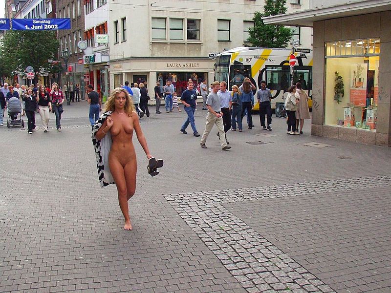Crazy blonde slut walks through town wearing nothing at all
