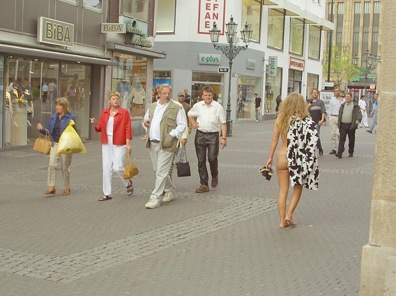 Crazy blonde slut walks through town wearing nothing at all