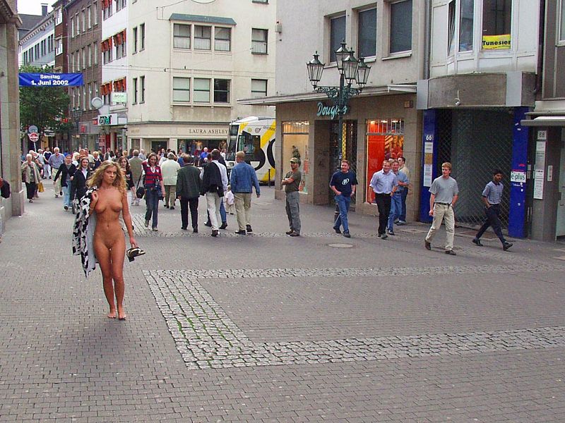 Crazy blonde slut walks through town wearing nothing at all