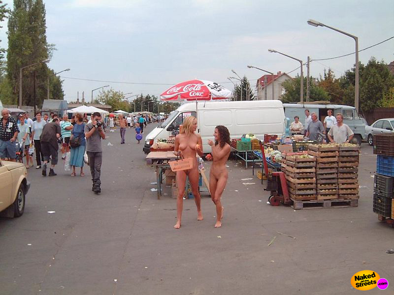Two girls walking around fully naked at a market