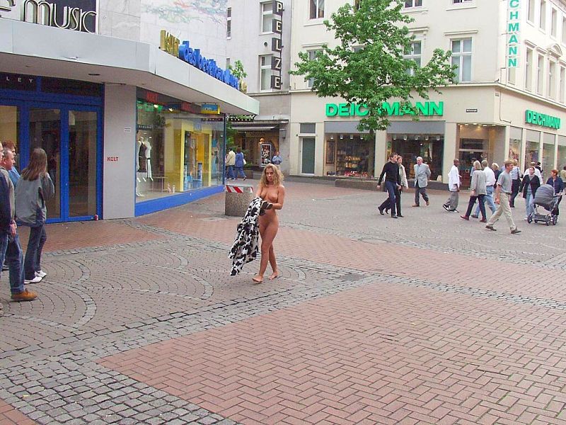 Crazy blonde slut walks through town wearing nothing at all