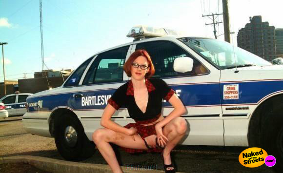 Kinky chick flashes pussy in front of a squad car