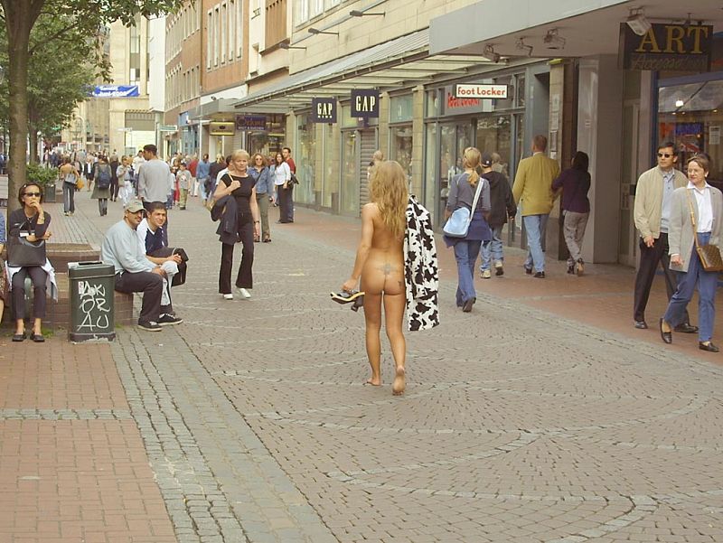 Crazy blonde slut walks through town wearing nothing at all