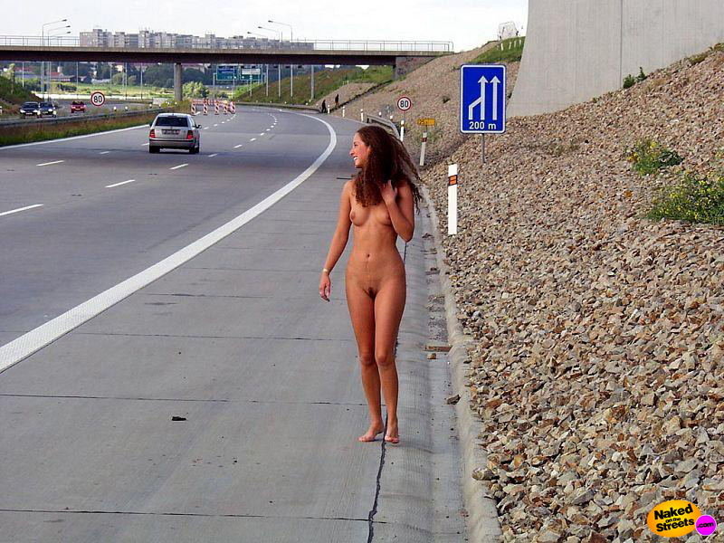 Sexy teen girl tries to hitch a ride fully nude on the highway shoulder