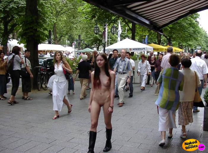 Young brunette teen walking through a busy shopping street fully nude