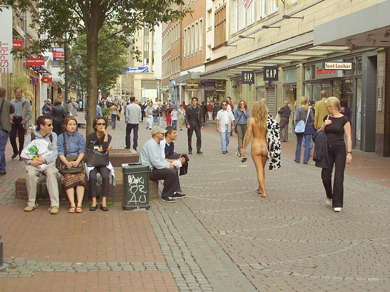 Crazy blonde slut walks through town wearing nothing at all