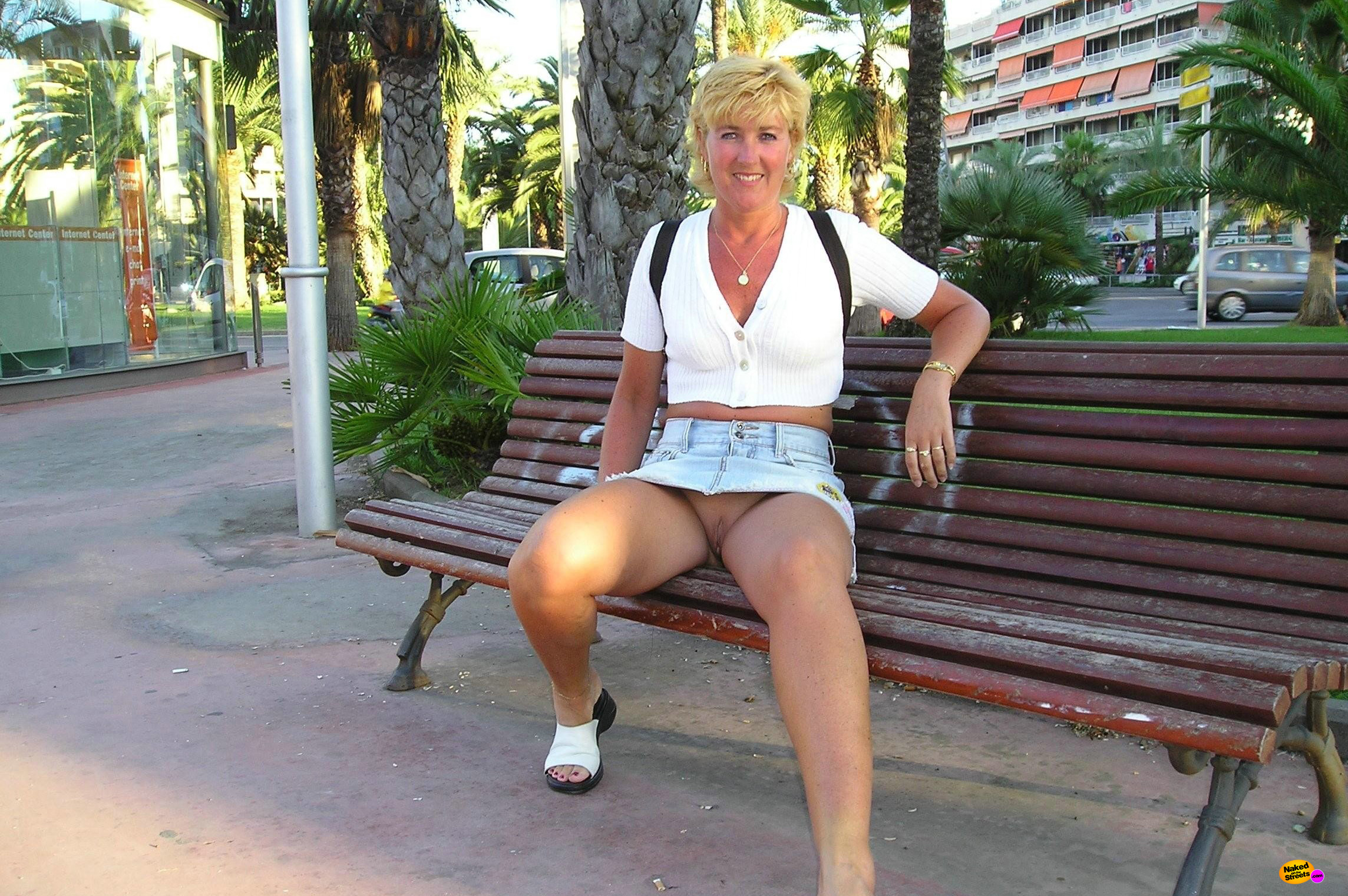 Short haired milf shows off her snatch on a bench