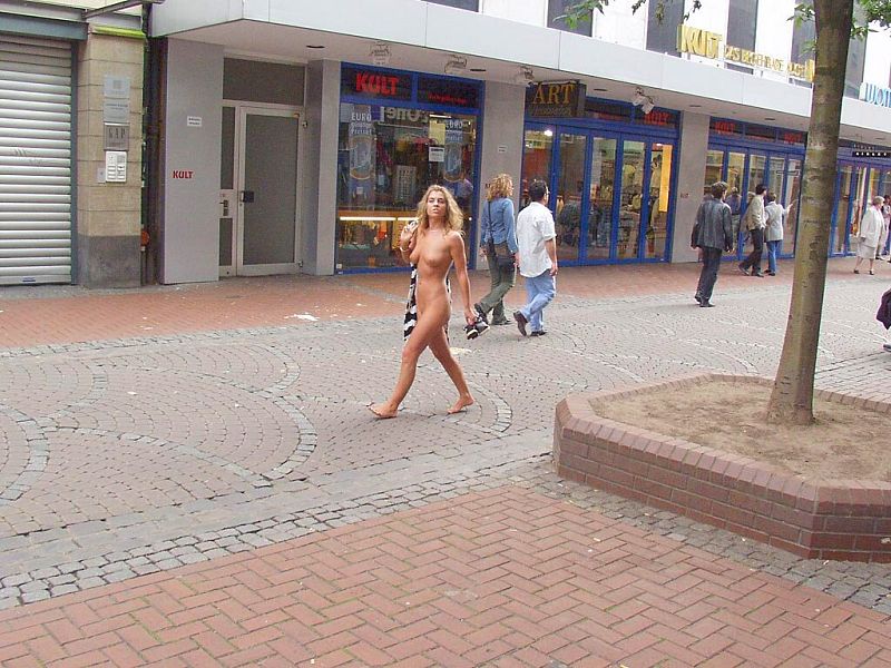 Crazy blonde slut walks through town wearing nothing at all
