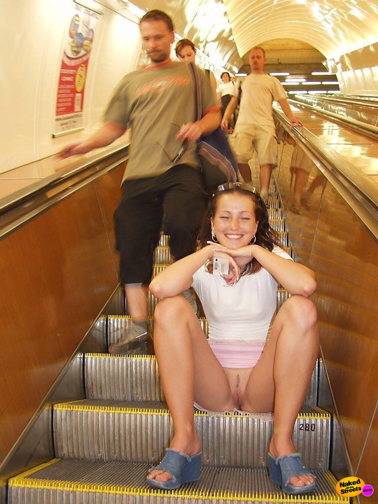 Naughty girl shows her snatch on escalator